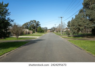 Background texture of a low density suburban street or low traffic road with wide nature strips and some residential houses in the neighbourhood in a Melbourne's outer suburb. Werribee VIC Australia.