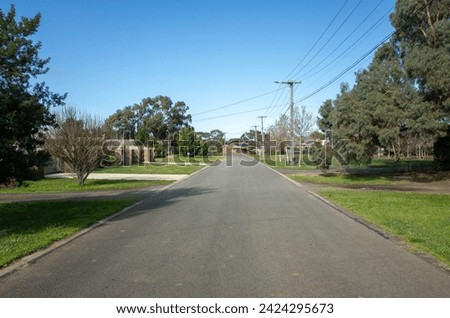 Background texture of a low density suburban street or low traffic road with wide nature strips and some residential houses in the neighbourhood in a Melbourne's outer suburb. Werribee VIC Australia.