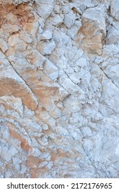 Fondo y textura de capas de montaña y grietas en roca sedimentaria sobre la cara del acantilado. 