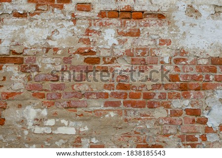 Background, texture of an old red brick wall with peeling white plaster