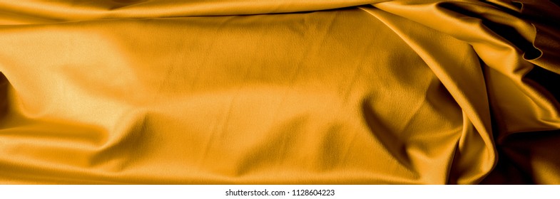 Background texture pattern of dark yellow silk fabric. An unrivaled example of excellent craftsmanship and fine craftsmanship brought by the Mughals in India He was well known for his design and gold
