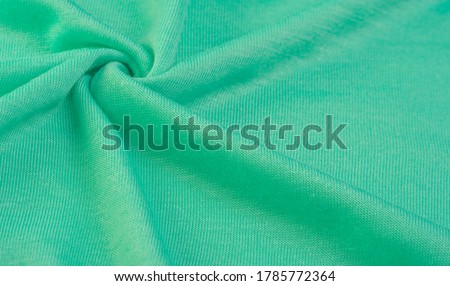 Background, texture, pattern, green wool fabric, thin soft curly or wavy hair forming the hair of a sheep, goat or similar animal, especially when they are used in the manufacture of fabric or yarn
