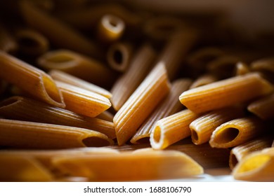 Background Texture And Pattern Of Whole Grains Penne Pasta. Close-up. Macro