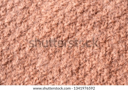 Background texture of pink beige pattern stitch knitted fabric made of cotton or wool. Close up.