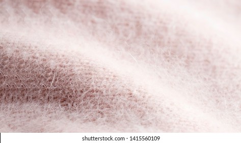 Background texture of pink pattern knitted fabric made of angora or wool. close up.