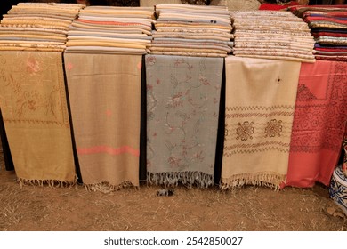 Background, texture samples of silk scarves in a textile shop, fabric, colorful, market, Silk in shop, Colorful women's shirts on hangers in a retail shop. Fashion and shopping concept


