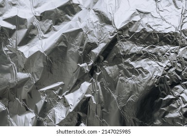 Background, Texture Of Silver Shiny Foil, Colored Crumpled Paper For Packing Goods. Close-up Photo, Top View, Copy Space.