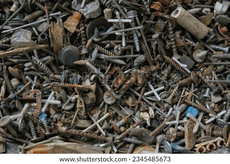 background and texture solid metal debris nails bolts and nuts loose. small consumables for repair and construction, paper clips and fasteners of various sizes lie in a pile.