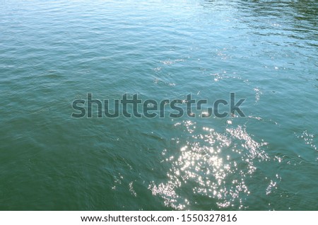 Background texture of sparkling rippling water in a river with reflections of the sunlight causing specular highlights