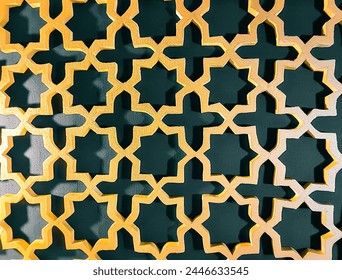 Background of a textured geometric pattern with an Islamic vintage design for decoration. The pattern is golden yellow and dark green. Handicraft patterns made from Styrofoam.