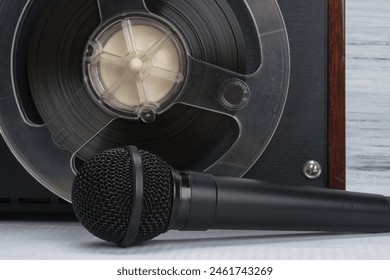 in the background there is a magnetic tape in a reel for recording music, there is a black microphone - Powered by Shutterstock