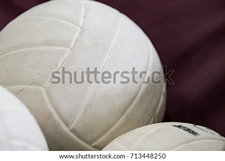 Background of three volleyballs on maroon