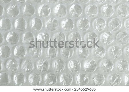 Background of transparent plastic bubble wrap. Close up of Bubblewrap material used for packing and safe handling of glass and delicate objects. Translucent plastics surface. Round bubbles.