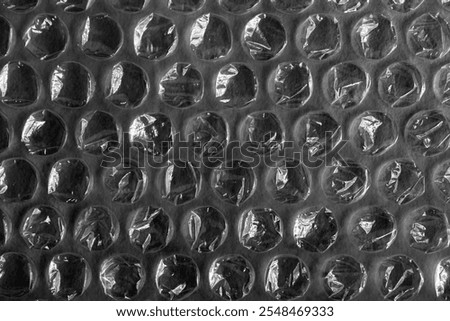 Background of transparent plastic bubble wrap. Close up of Bubblewrap material used for packing and safe handling of glass and delicate objects. Translucent plastics surface. Round bubbles.