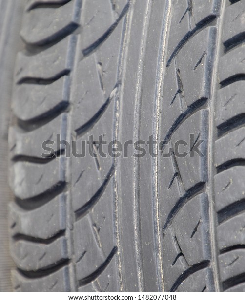 The background of the tread pattern of the car\
wheel. Rubber tires.