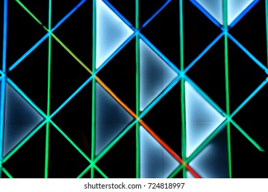 Background triangular LED lights. Black tech structure holding blue neon lights. 