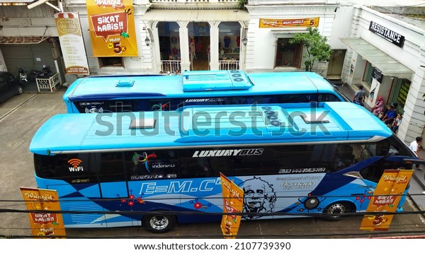 Background, Two\
buses are parked in front of a shopping area in Cihampelas Bandung,\
West Java, January 17,\
2022
