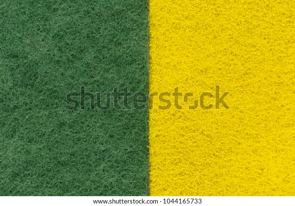 background of two colored\
green and yellow non-woven fibrous abrasive material, divided\
vertically