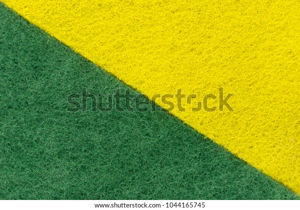 background of two colored\
green and yellow non-woven fibrous abrasive material, divided\
diagonally