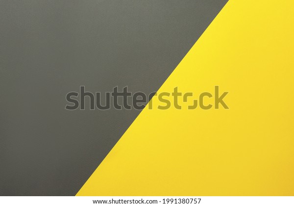 Background of two colors.\
Yellow and gray colored paper sheets divided diagonally. Flat lay,\
top view.