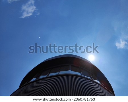 Background of A unique circular building that covers the sun in the blue sky