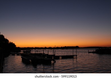 Background view of the dramatic sun rise and orange blue sky by the pier