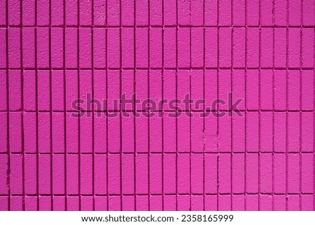 Background from a wall made of rectangular pink mosaic tiles