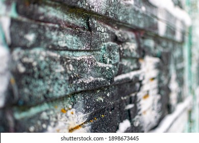 Background with a wall structure covered with large granite stones close-up, overgrown with moss