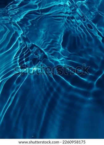 The​ metal​ texture​ of​ surface​ blue​ water​ reflected​ by​ sunlight​ for​ background. Blue​ water​ texture​ in​ the deep​ sea​ for​ background. Reflection​ on​ surface​ blue​ water. Blue​ water​