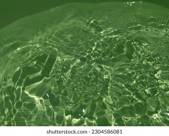 The​ metal​ texture​ of​ surface​ blue​ water​ reflected​ by​ sunlight​ for​ background. Blue​ water​ texture​ in​ deep​ sea​ for​ background. Reflection​ on​ surface​ blue​ water. Green​ wwater art.