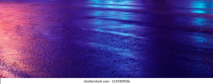 Background of wet asphalt with neon light. Blurred background, night lights, reflection.
