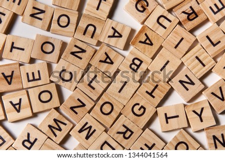 Background of wooden alphabet letters scattered randomly on white background