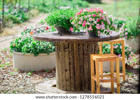 The background of a wooden chair, a wooden table that is placed to sit, relax or bring a garden, place a vase of flowers for the beauty of the witness.
