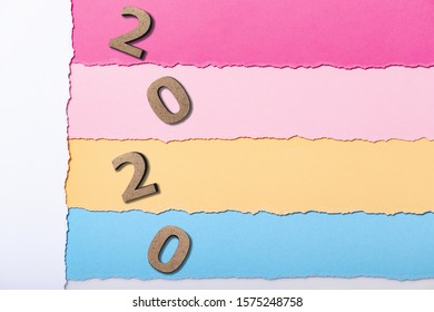 Background With Wooden Figures Of The Date 2020 On Multicolored Cardboard Stripes, New Year Concept, School Calendar Cover Design