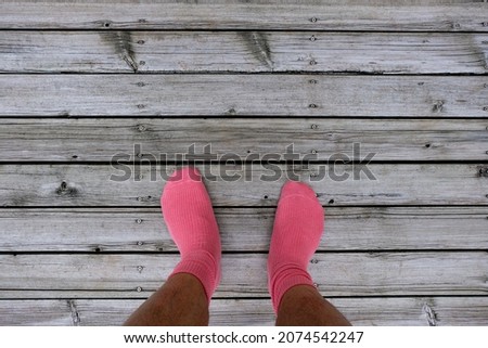background of wooden floor with feet wearing pink socks