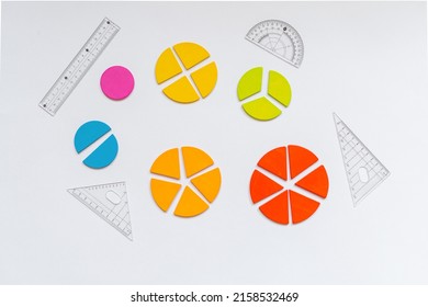 Background Of Wooden Pie Charts. Multicolored Math Fractions, Rulers, Pencils On White Background. Interesting, Fun Math For Kids. Education, Back To School Concept