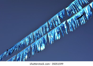 Backgrounds: Blue Metallic Streamers Sparkle In The Wind Against A Blue Sky