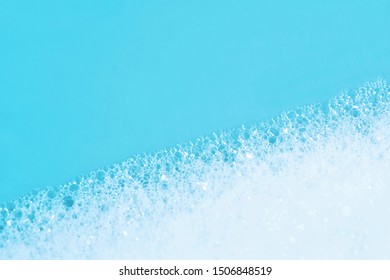 Backgrounds Of Blue Wet Soap Bubbles On Blue Background. Laundry Detergent, Suds Textured Pattern. White Soap Suds Macro View. Abstract Textured Effect Of Blue Soap Foam Close-up. Divided Frame