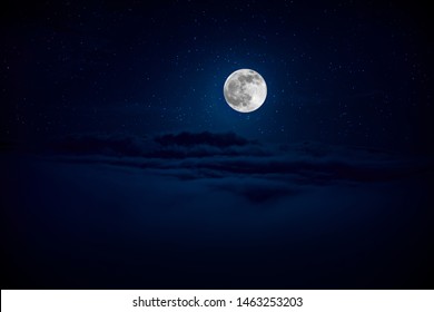 backgrounds night sky with stars and moon and clouds. Beautiful full moon over clouds during night time
