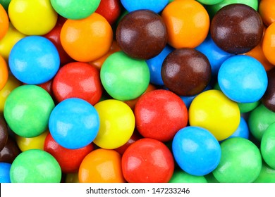 Backgroynd of chocolate balls in colorful glaze.