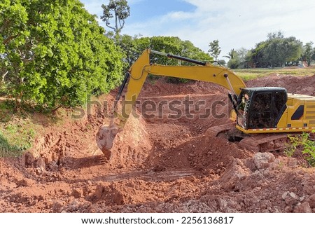 Backhoe bucket digging the soil at agriculture farm to make pond. Crawler excavator digging at shale layer. Excavating machine. Earth moving equipment. Excavation vehicle. Construction business.