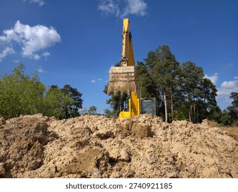 The backhoe is digging the ground.