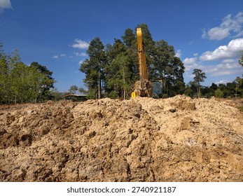 The backhoe is digging the ground.