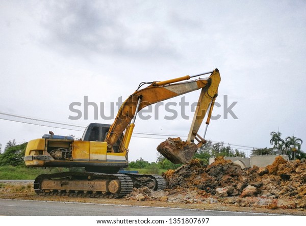Backhoe to excavate the soil on the\
ground construction site excavator. Installed construction of\
concrete pipe of drainage system work on the side of the road\
