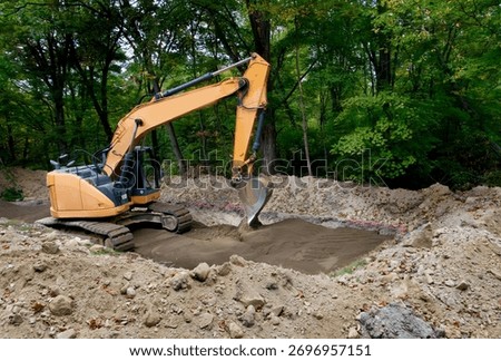 Backhoe leveling sand that has been laid as the bottom level of a septic system drain field