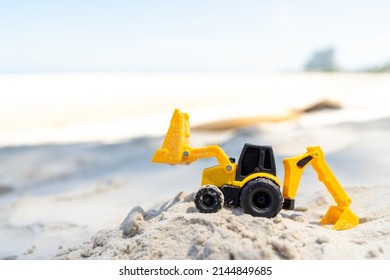 Backhoe toy yellow plastic on beach sand - Powered by Shutterstock