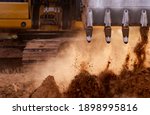 Backhoe working by digging soil at construction site. Bucket teeth of backhoe digging soil. Crawler excavator digging on soil. Excavating machine. Earth moving machine. Excavation vehicle.