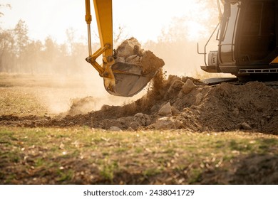 Backhoe working by digging soil at construction site. Bucket teeth of backhoe digging soil. Crawler excavator digging on soil. Excavating machine. Earth moving machine. Excavation vehicle.