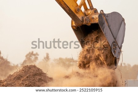 Backhoe working by digging soil at construction site bucket of crawler excavator breaking ground for new development project earth moving machine in action. Foundation work on construction project.