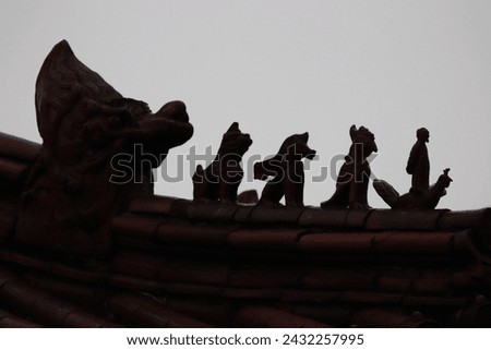 Backlight silhouette of black fantasy figures like dragon sculpture, religious architectural ornament and spiritual asian decorations on old traditional roof of taiwanese temple, Taipei, Taiwan, Asia.